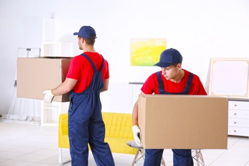 Specialist piano movers preparing an upright piano for safe removal in Kingston